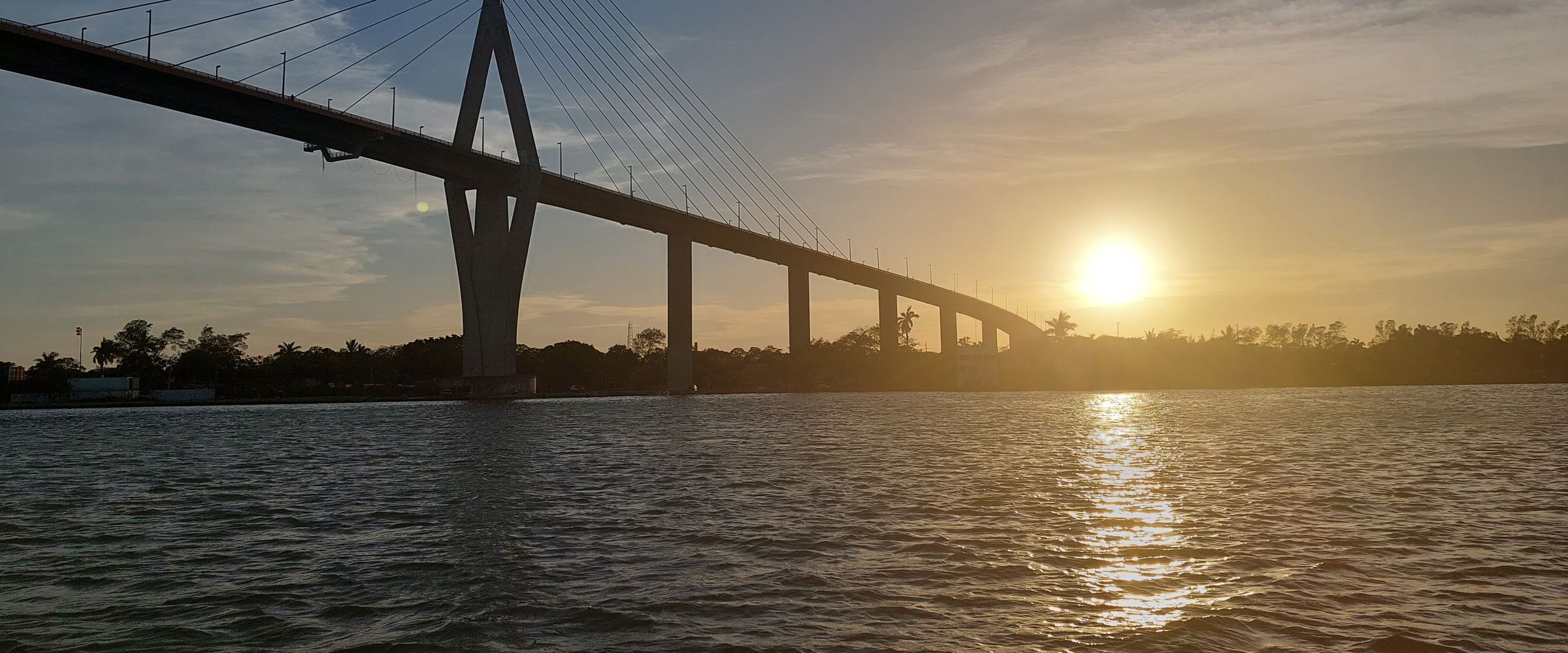 El Puente Tampico sobre el río Pánuco al atardecer, visto desde el agua.